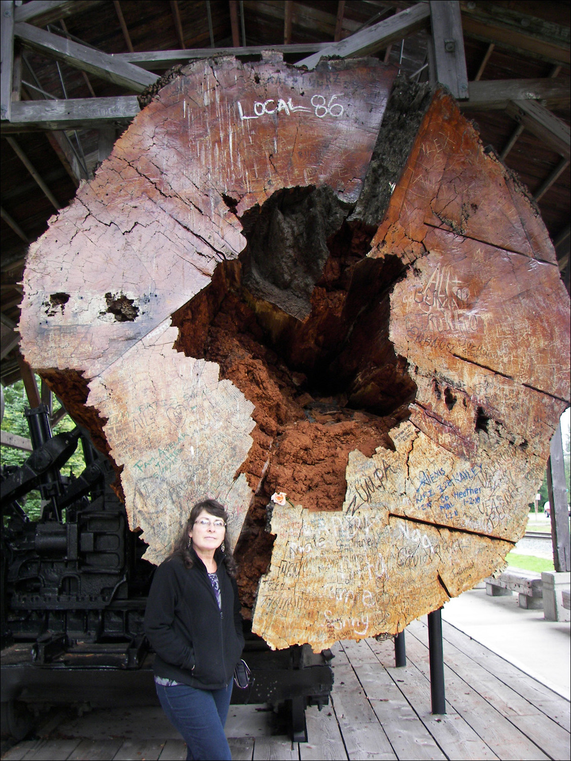 Snoqualmie, WA- Katheriine stands next to large log